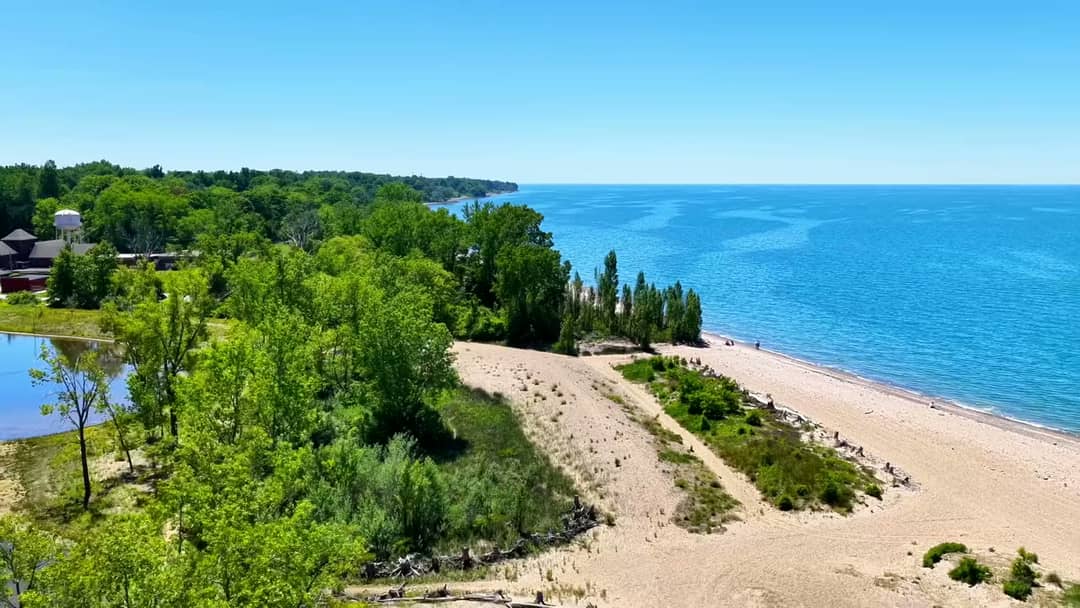Aerial view of a lakeside park and beach on a clear summer day, filmed by Horizon Heights Productions.