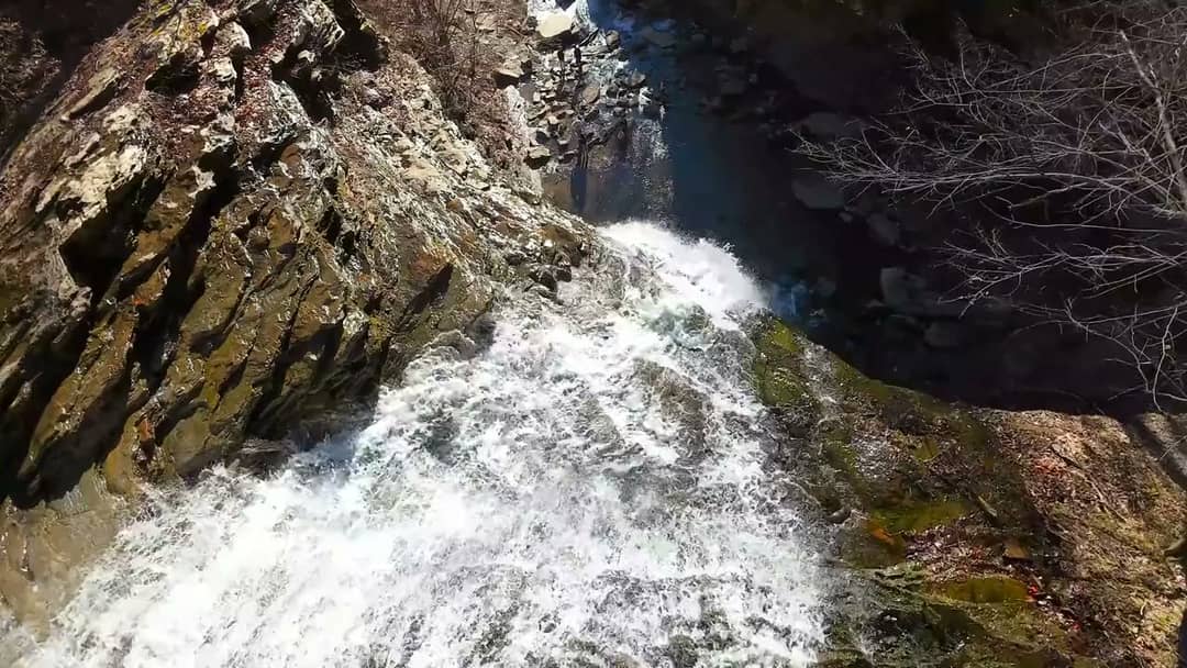 Dramatic drone shots of waterfalls in a rugged river gorge, filmed by Horizon Heights Productions.