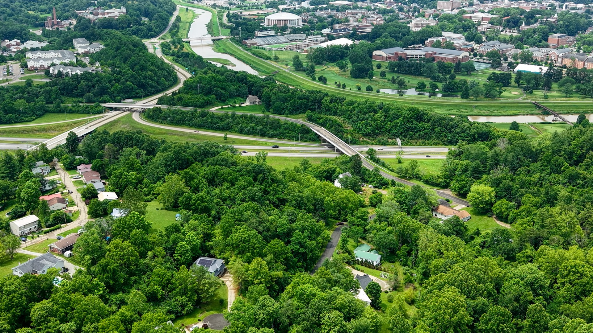 Drone aerial of a 50-plus-acre farmland tract in Washington County showing tillable fields, tree lines, and creek access