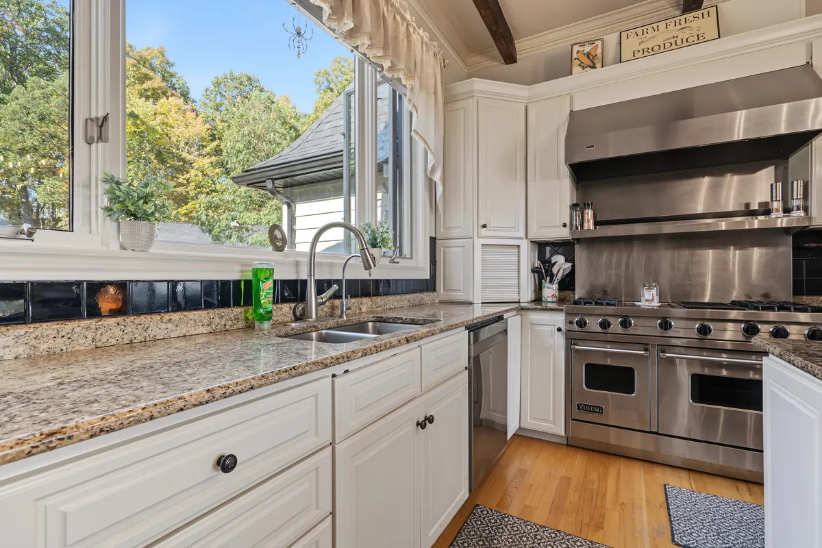 Kitchen corner with granite counters, a window over the sink and a Viking double-oven range under a stainless hood. 469 Vincent Hill Rd, Cairo, West Virginia, shot for Whitetail Properties.